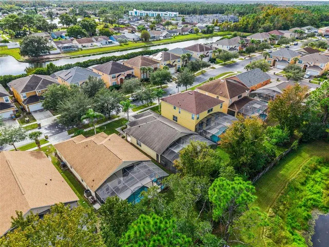 an aerial view of residential houses with outdoor space and lake view