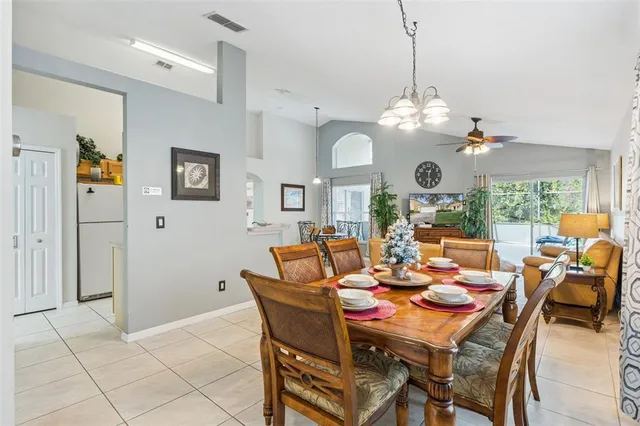 a dining room filled chandelier and wooden floor