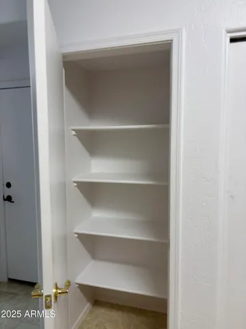 a view of walk in closet with empty racks