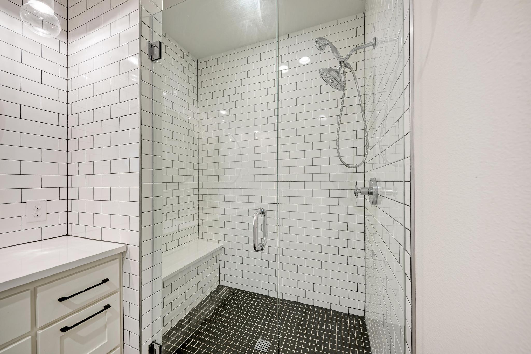 918 Cardinal Lane, Unit A Austin, TX 78704 - Photo 21 of 40 Soak away your stress in the spa-inspired oversized walk-in shower with bench seating, tile surround, and frameless glass.