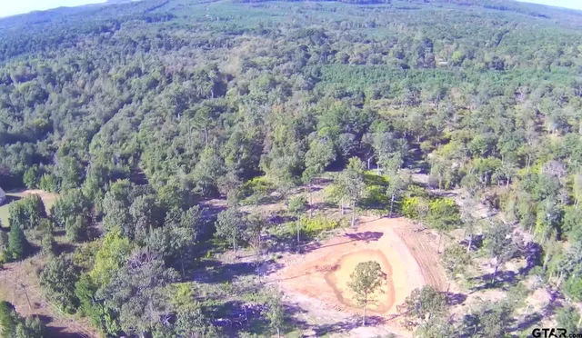 a view of a dry yard with wooden fence