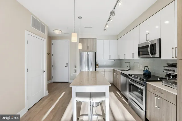 a kitchen with stainless steel appliances a stove a sink and a refrigerator