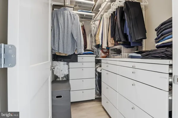 a view of walk in closet with clothes