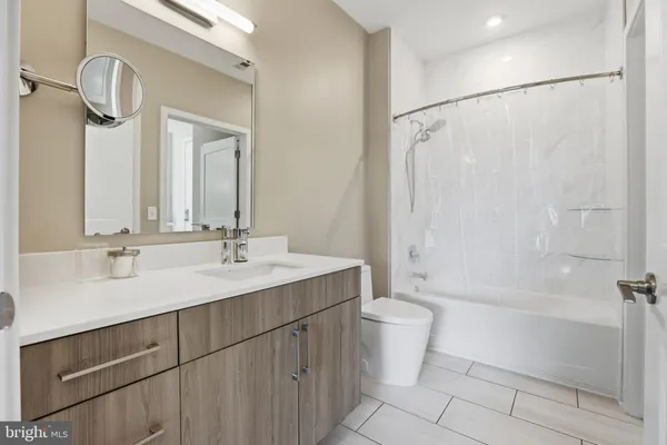 a bathroom with a double vanity sink toilet mirror and shower