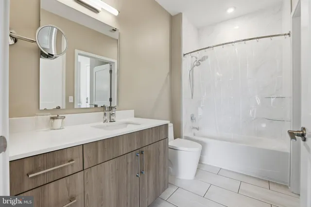 a bathroom with a double vanity sink toilet mirror and shower
