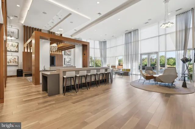 a dining hall with stainless steel appliances granite countertop a stove and chairs