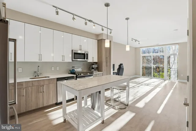 a kitchen with stainless steel appliances granite countertop a stove a sink dishwasher and a refrigerator with wooden floor