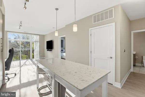 a view of a kitchen with kitchen island a sink wooden floor and living room view