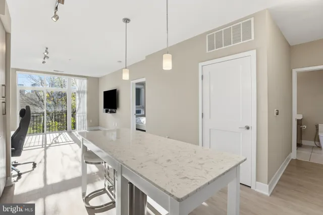 a view of a kitchen with kitchen island a sink wooden floor and living room view