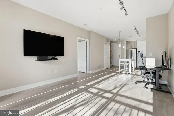 a view of a livingroom with wooden floor and a flat screen tv
