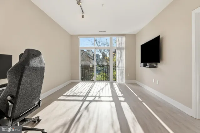 a view of a livingroom with wooden floor and a flat screen tv