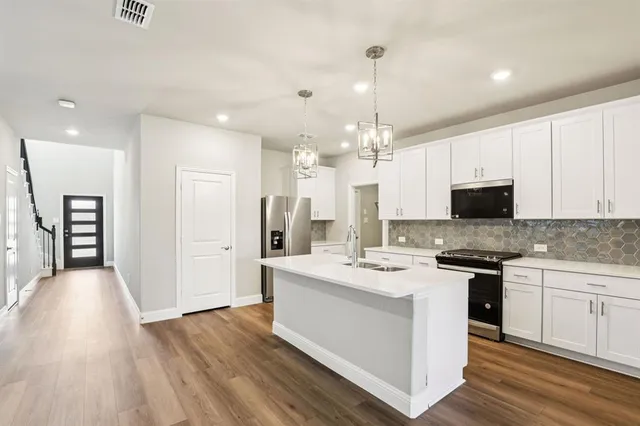 a kitchen with stainless steel appliances kitchen island a white cabinets and sink