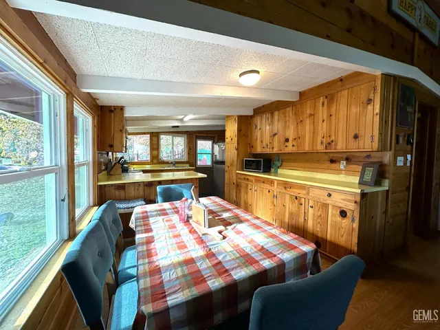 a kitchen with stainless steel appliances kitchen island granite countertop a refrigerator a stove top oven and a dining table with garden view