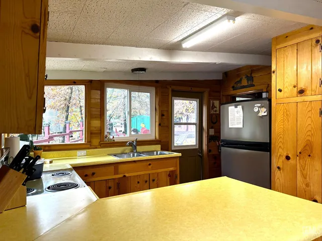 a kitchen with stainless steel appliances kitchen island granite countertop a refrigerator and a sink