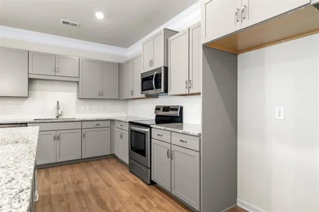 a kitchen with granite countertop cabinets stainless steel appliances and a sink