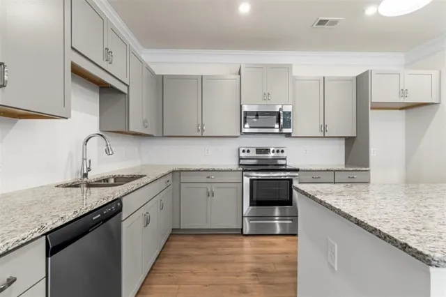 a kitchen with stainless steel appliances granite countertop a sink stove and cabinets