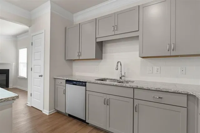 a kitchen with stainless steel appliances granite countertop white cabinets sink and dishwasher
