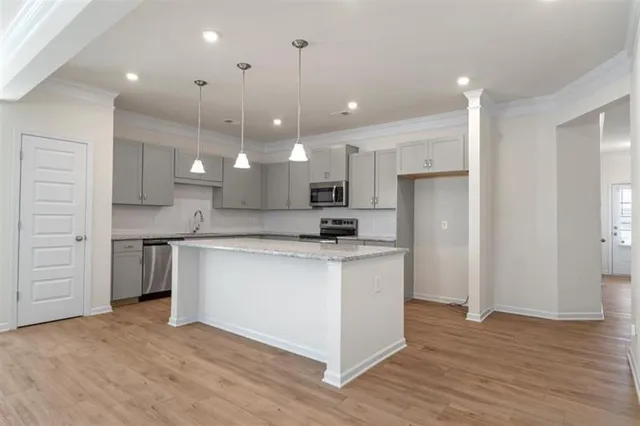 a kitchen with kitchen island a sink stainless steel appliances and cabinets