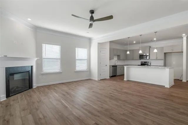 a view of kitchen with granite countertop stainless steel appliances cabinets a sink and a fireplace