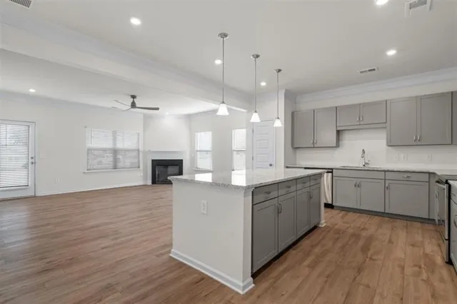 a large kitchen with granite countertop a large counter top a sink stainless steel appliances and cabinets