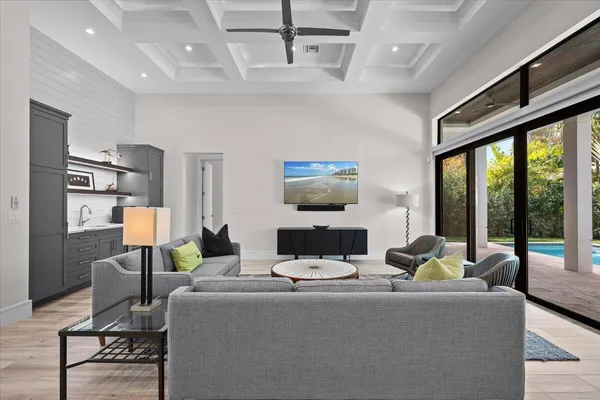 a living room with furniture kitchen view and a chandelier