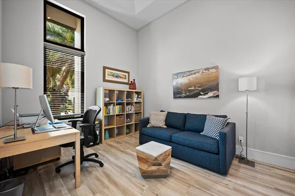 a view of a hallway with wooden floor and workspace