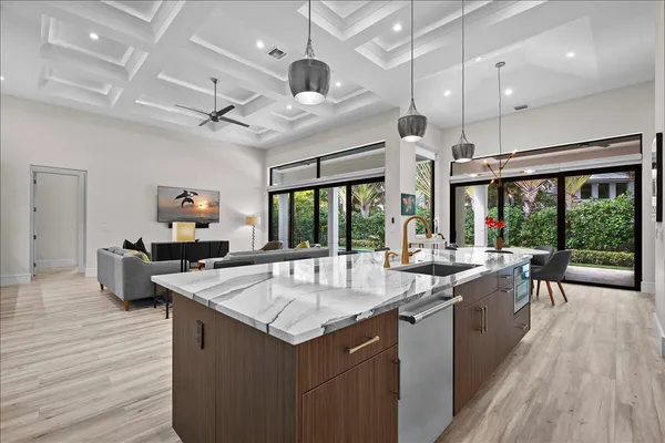 a kitchen with stainless steel appliances granite countertop a table chairs stove and wooden cabinets