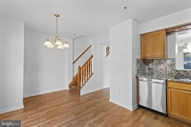 a view of an empty room with wooden floor and staircase
