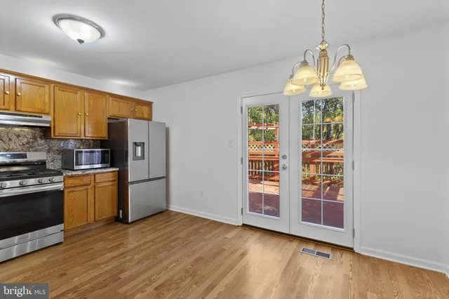 a kitchen with stainless steel appliances granite countertop a refrigerator and a stove top oven