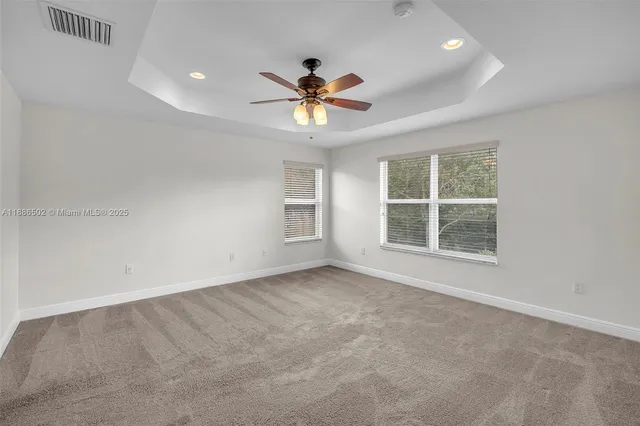 an empty room with windows and fan