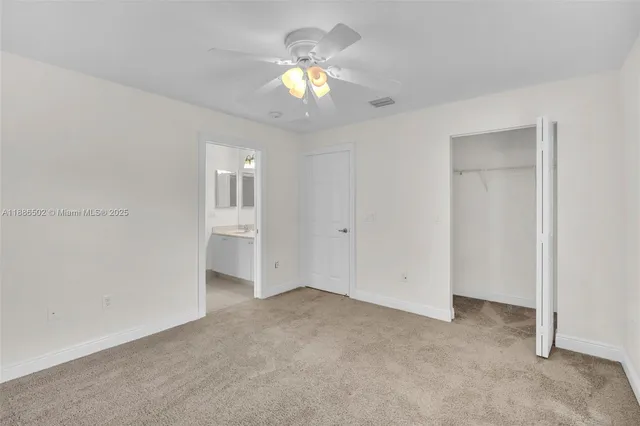 a view of an empty room with a chandelier fan