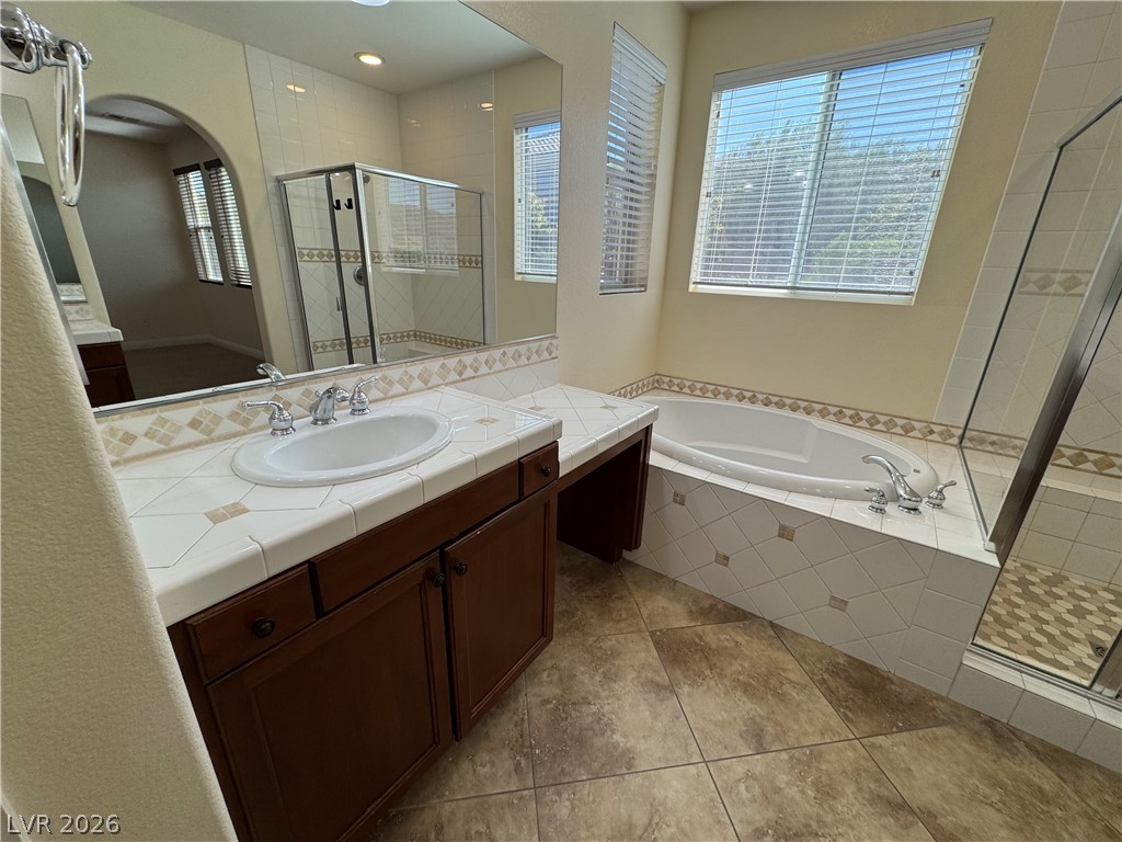 1333 Jamesbury Road Las Vegas, NV 89135 - Photo 34 of 43 A well-lit bathroom features a large soaking tub and a separate glass-enclosed shower.