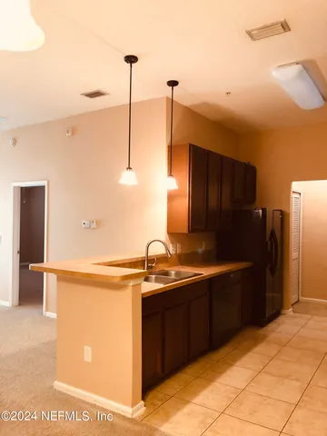 a view of a kitchen with a sink and a refrigerator
