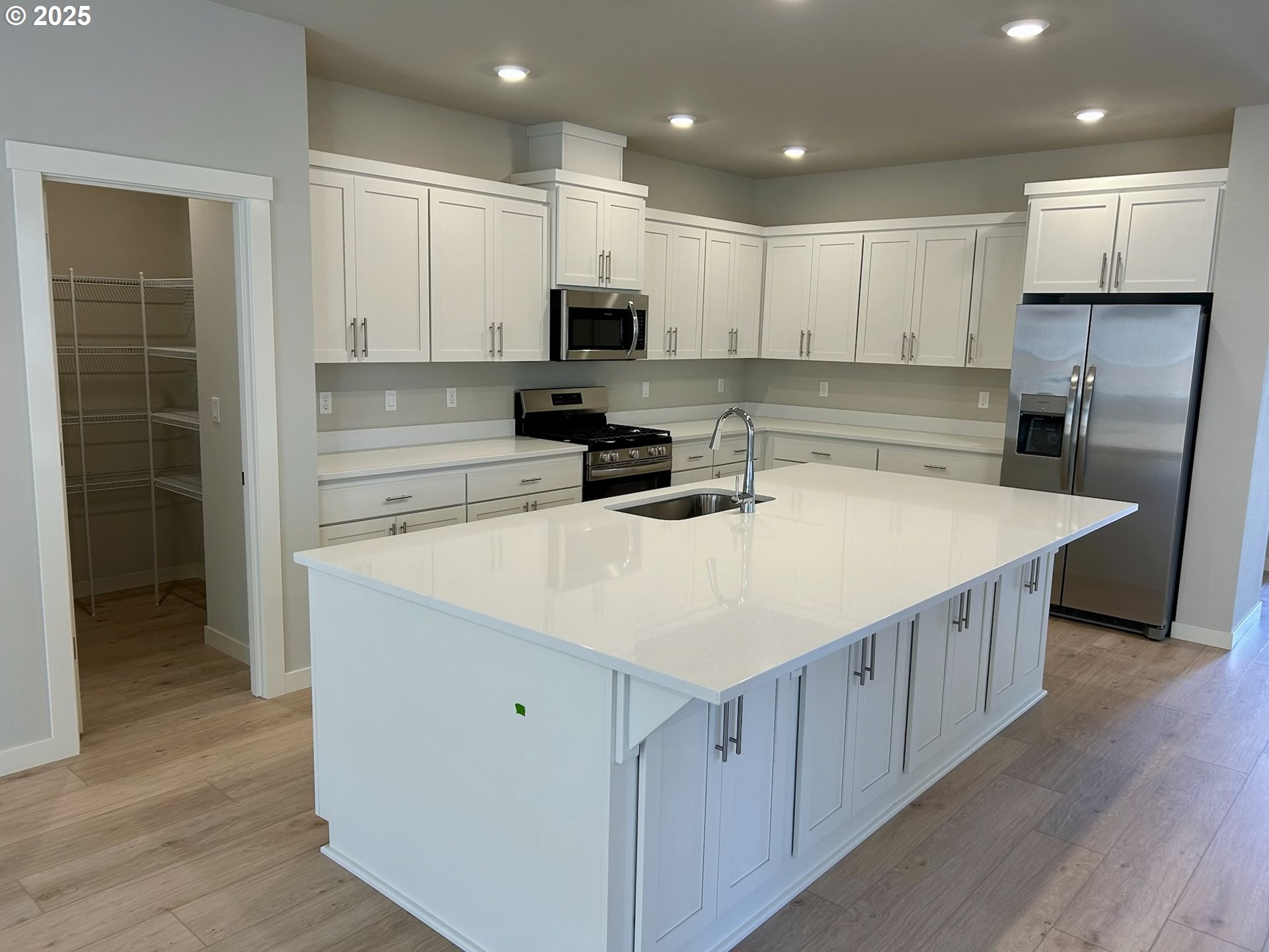 14956 Southwest 165th Avenue Tigard, OR 97224 - Photo 25 of 43 a kitchen with stainless steel appliances white cabinets and wooden floor