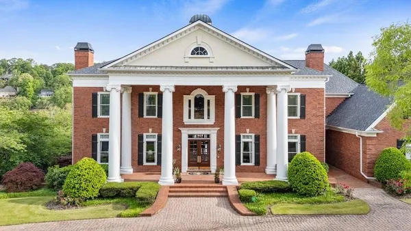 a front view of a residential houses with yard and green space