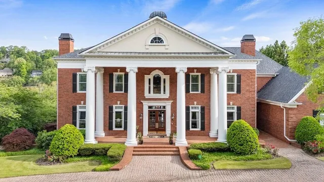 a front view of a residential houses with yard and green space