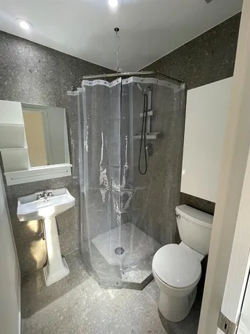 a bathroom with a toilet and a shower