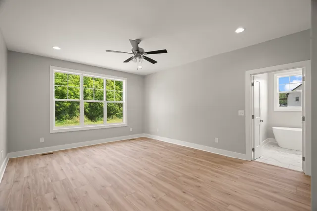 a view of an empty room with glass door and wooden floor