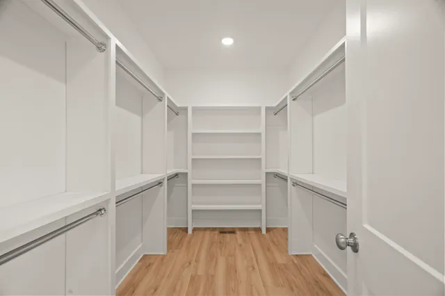 a view of walk in closet with empty racks
