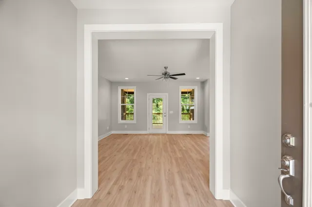a view of a hallway with wooden floor and a window