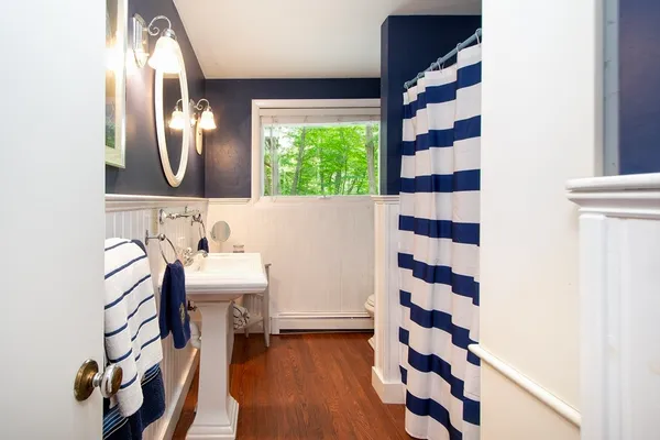 a bathroom with a sink a toilet a mirror and shower