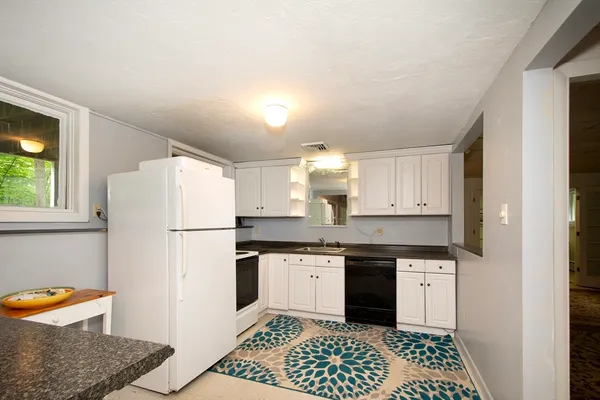 a kitchen with a sink a refrigerator and cabinets