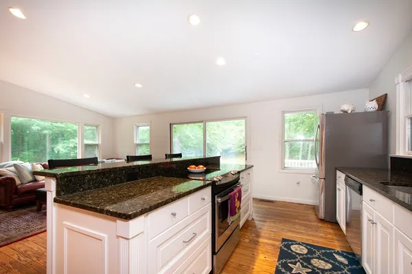 a kitchen with granite countertop a sink and a stove top oven