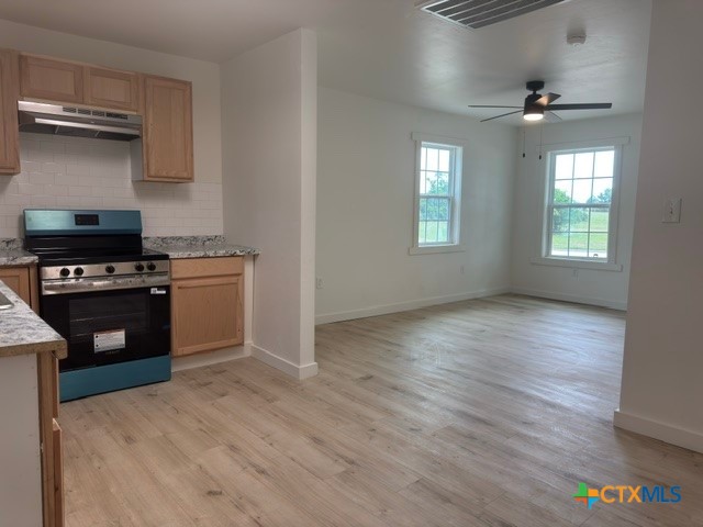602 South 26th Street Temple, TX 76501 - Photo 4 of 11 a kitchen with granite countertop a stove and a wooden floors