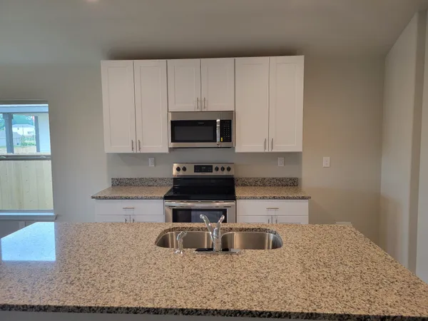a kitchen with sink cabinets and microwave