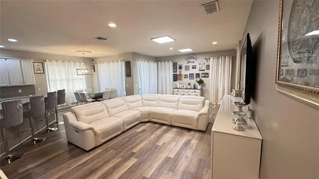 a living room with furniture and a wooden floor