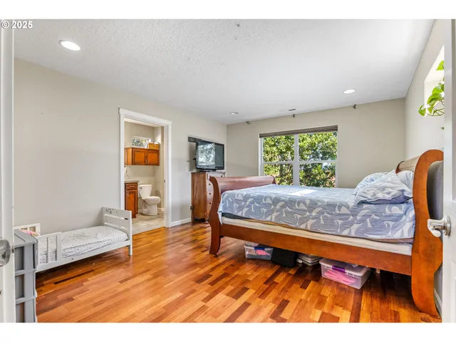 a bedroom with a bed and wooden floor