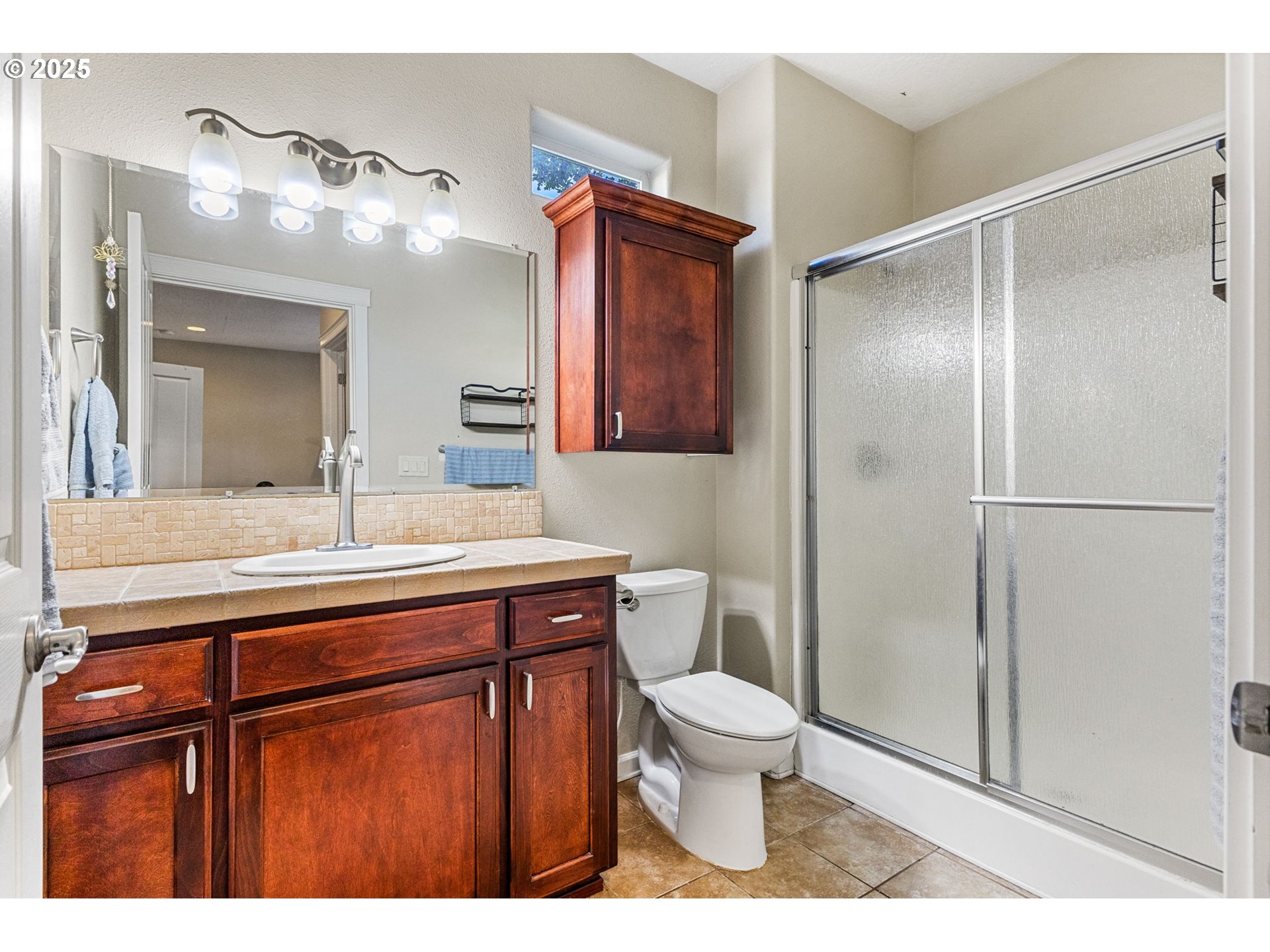 610 Northwest Hillcrest Drive Dallas, OR 97338 - Photo 21 of 32 a bathroom with a sink a toilet a mirror and shower