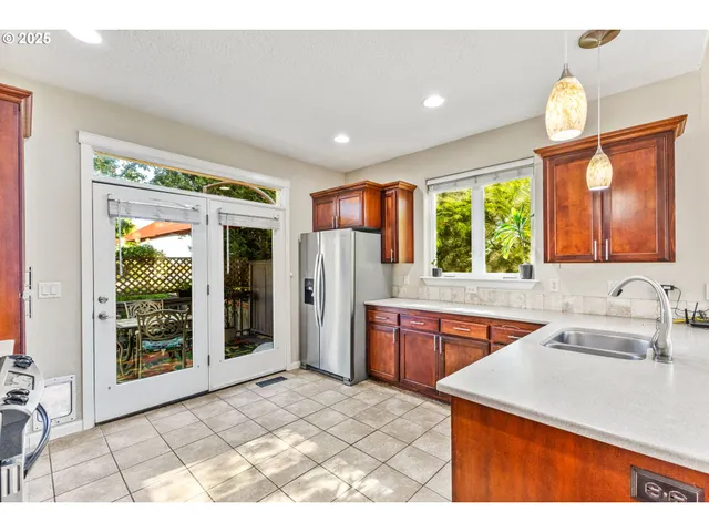 a kitchen with a sink cabinets stainless steel appliances and a large window