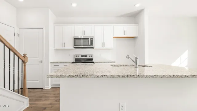 a kitchen with stainless steel appliances granite countertop a sink a stove and a refrigerator